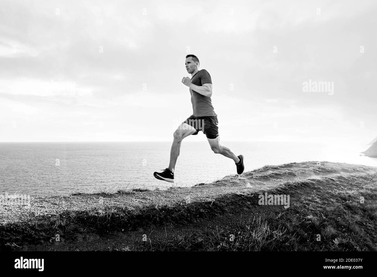un athlète d'homme mature s'exécute sur un sentier de montagne noir et blanc image Banque D'Images