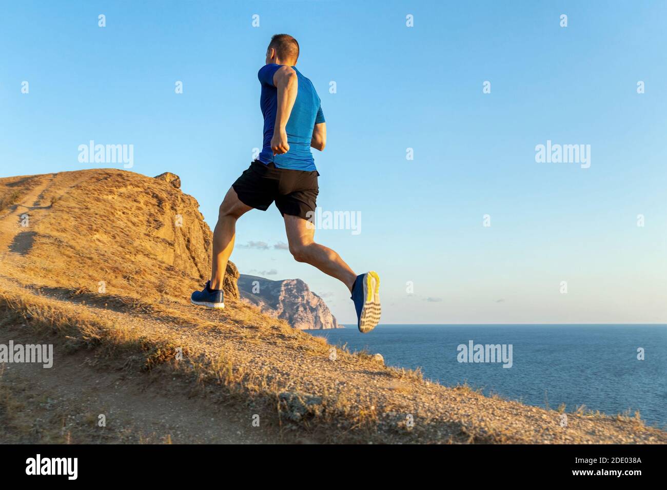le coureur de fond monte en arrière-plan dans le ciel et la mer Banque D'Images