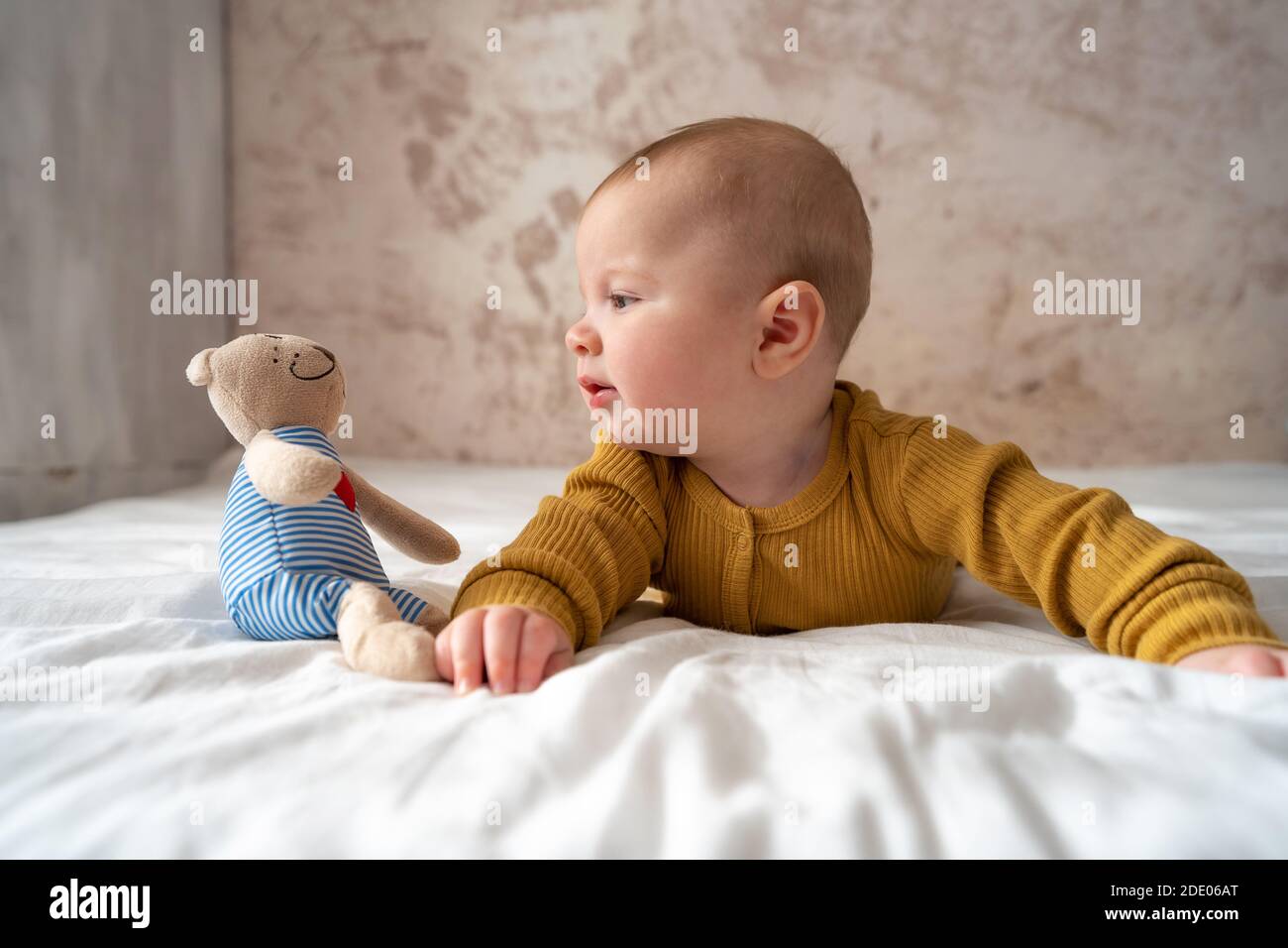 Vue Du Haut Portrait D Un Nouveau Ne Mignon Bebe Garcon Portait Bodysuit Bebe Sur Le Lit Charmant Bebe De 5 Mois Se Trouve Dans Le Lit Avec Une Poupee Plaisir Et Heureux Photo