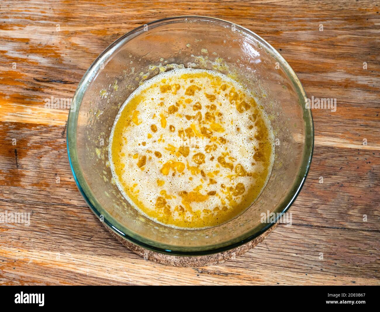 faire cuire un gâteau éponge sucré à la maison - vue de dessus d'un mélange sucré d'œufs, de sucre et de miel pour la pâte cuite dans un bain d'eau dans un bol en verre sur de vieux tabl en bois Banque D'Images
