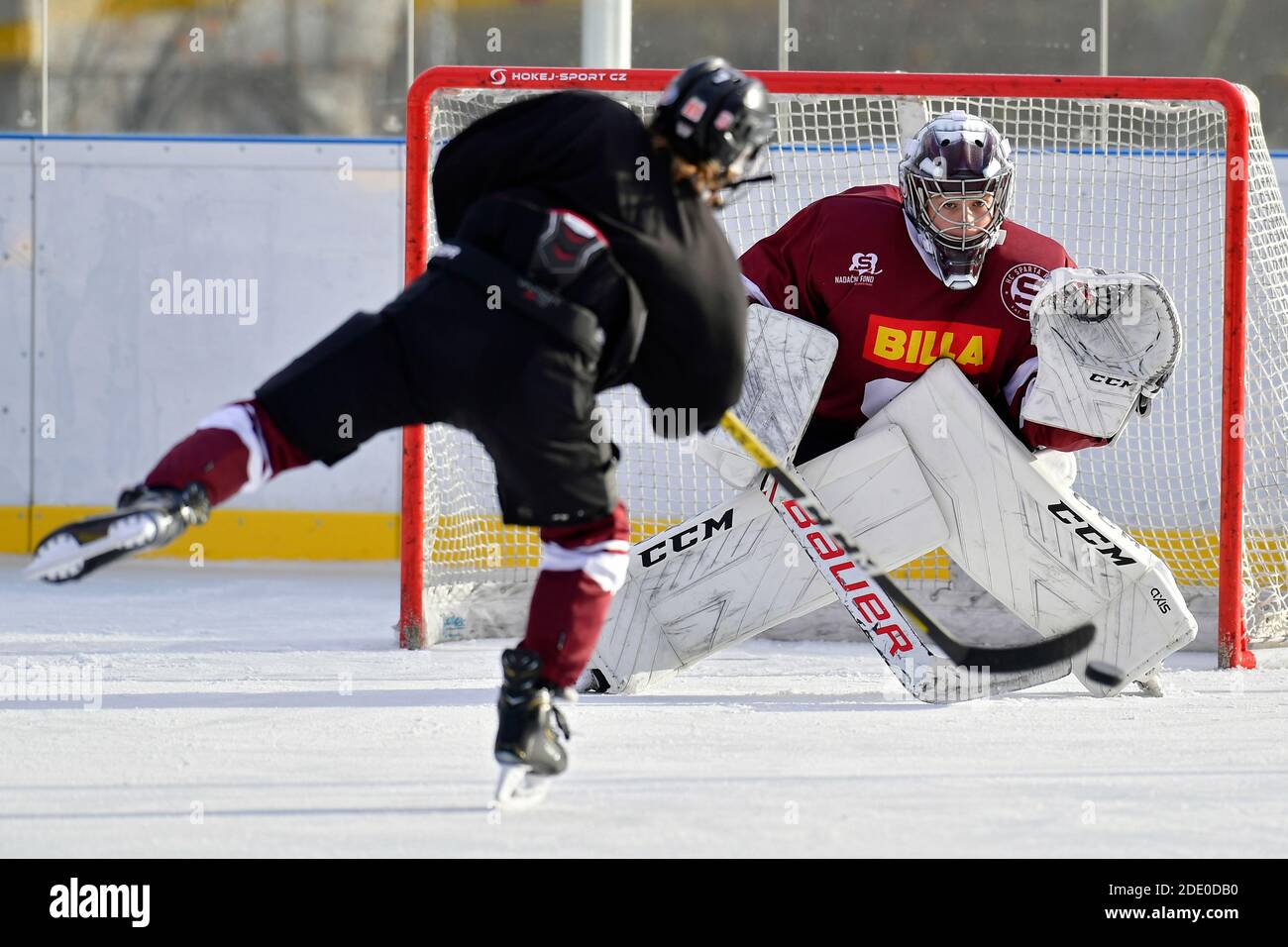 un joueur de hockey de jeunesse prend des coups de feu sur le gardien de but pendant le hockey sur glace en plein air formation Banque D'Images