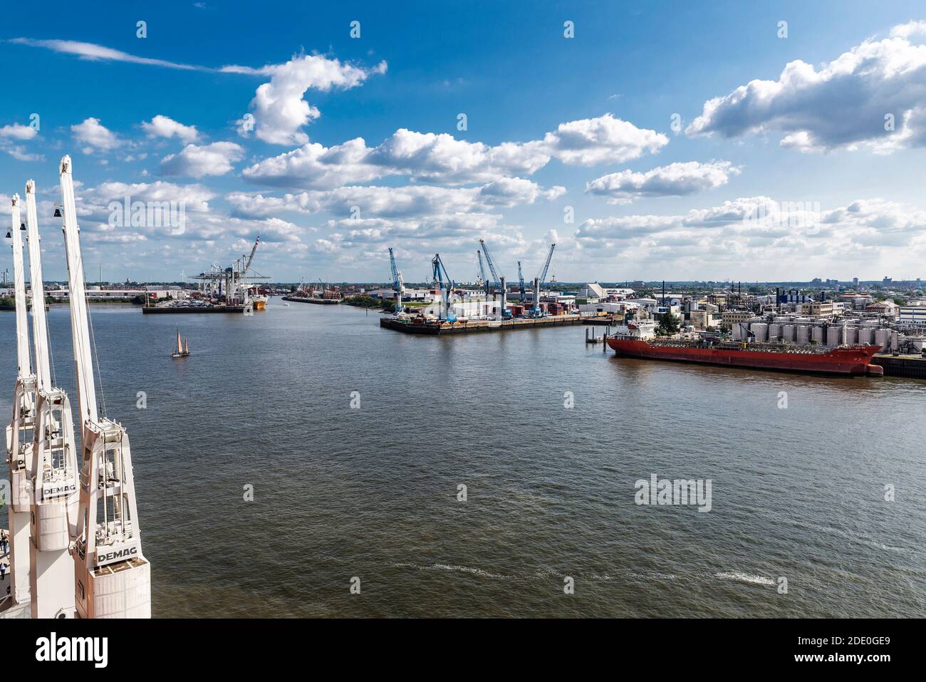 Hambourg, Allemagne - 21 août 2019 : vue d'ensemble d'une grue à conteneurs et d'un voilier naviguant dans le port de l'Elbe à Hambourg, Allemagne Banque D'Images