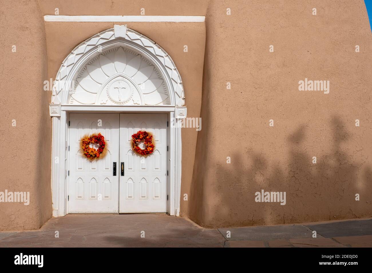 Portes d'entrée blanches sculptées à l'église adobe Mission de San Francisco de Asis - Saint François d'Assissi - à Ranchos de Taos, Nouveau-Mexique, Etats-Unis Banque D'Images
