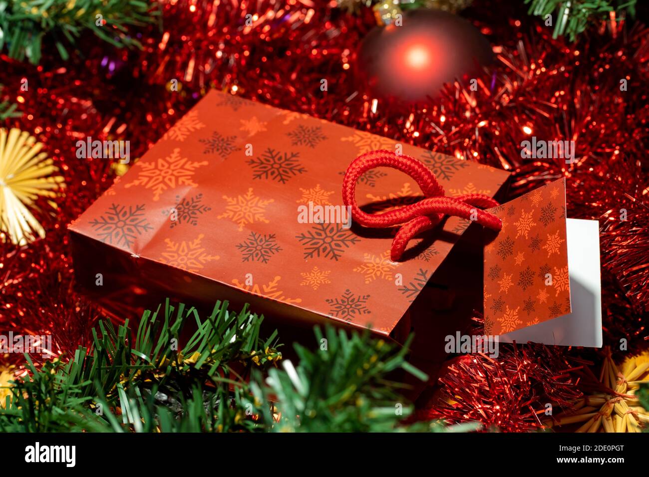 Le petit sac de Noël avec cadeau et une étiquette, un fond des décorations de Noël. Banque D'Images