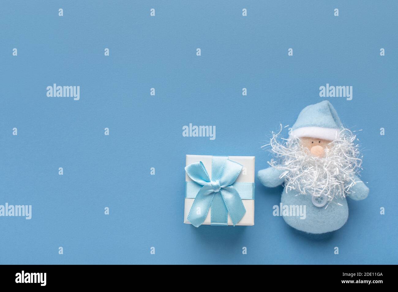 Belle délicate salutation carte de Noël du nouvel an dans la couleur bleu pastel. Concept avec place pour zone de texte avec cadeau et noeud et Père Noël barbu. Banque D'Images