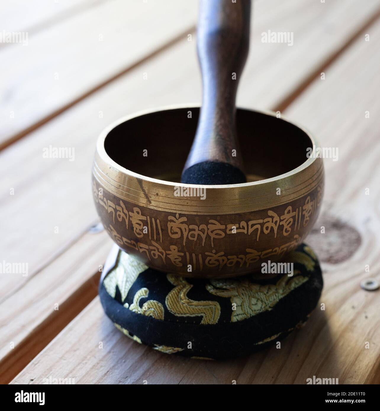 Gros plan de la coupe de chant tibétaine sur un coussin orné de bois arrière-plan Banque D'Images