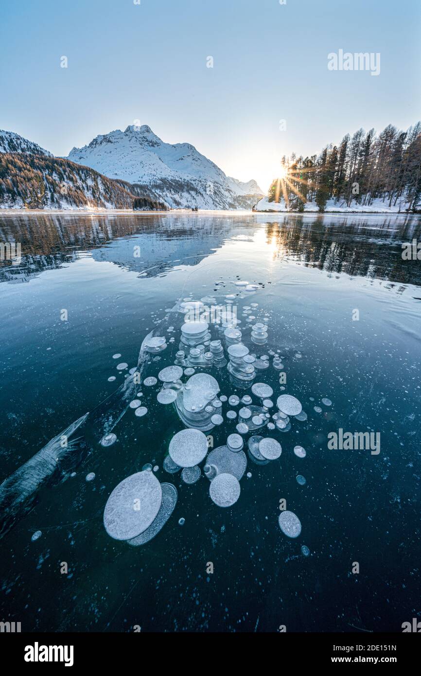Bulles de glace piégées dans le lac gelé Sils au coucher du soleil avec Piz Da la Margna en arrière-plan, Engadine, canton de Graubunden, Suisse, Europe Banque D'Images