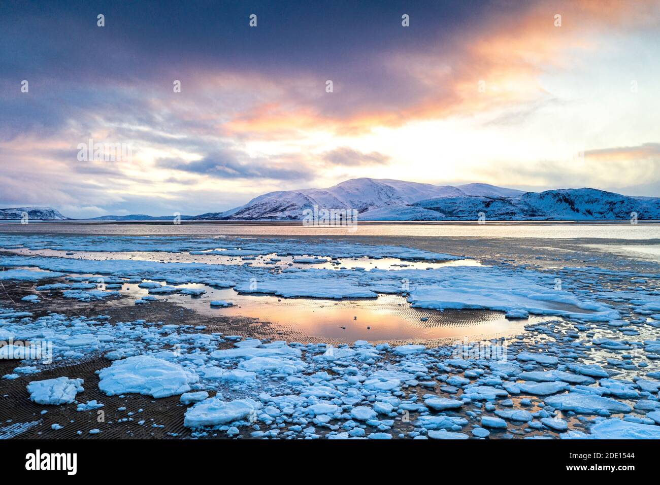 Coucher de soleil arctique sur les montagnes enneigées et la mer gelée, Réserve naturelle de Tanamunningen, Leirpollen, Troms og Finnmark, Arctique, Norvège Banque D'Images