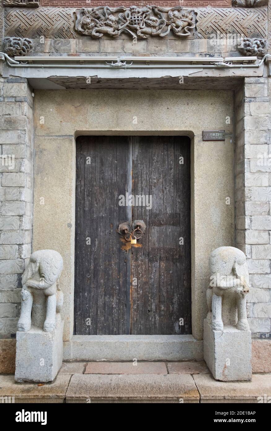 Statues en pierre par la porte en bois d'une maison traditionnelle dans la vieille ville de Huishan, Wuxi, province de Jiangsu, Chine Banque D'Images