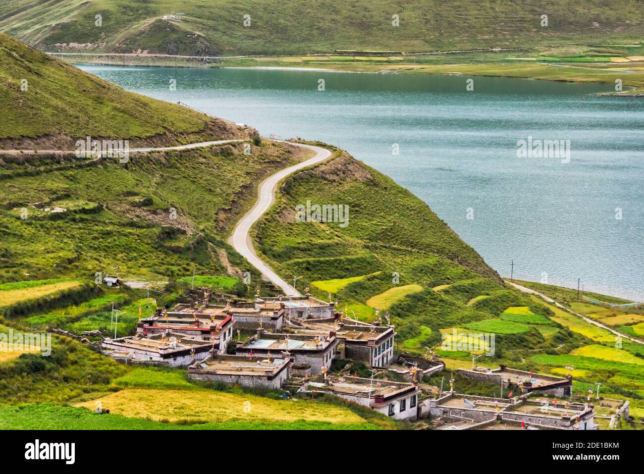 Champ d'orge et village sur la rive du lac Yamdrok (Yamdrok Yumtso), Tibet, Chine Banque D'Images