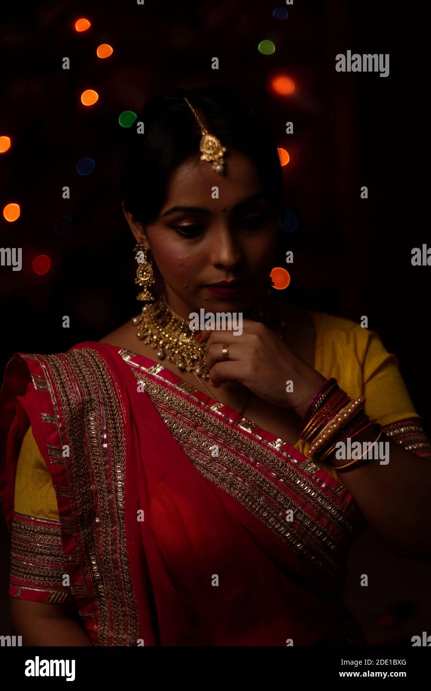 Portrait d'une femme bengali indienne magnifique brunette devant le fond bokeh lumineux coloré dans la soirée de Diwali. Style de vie indien Banque D'Images