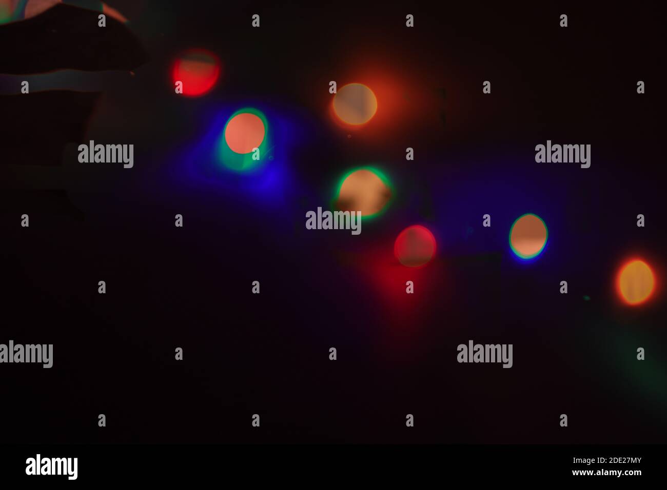 Lumière de Noël colorée floue sur fond noir Banque D'Images