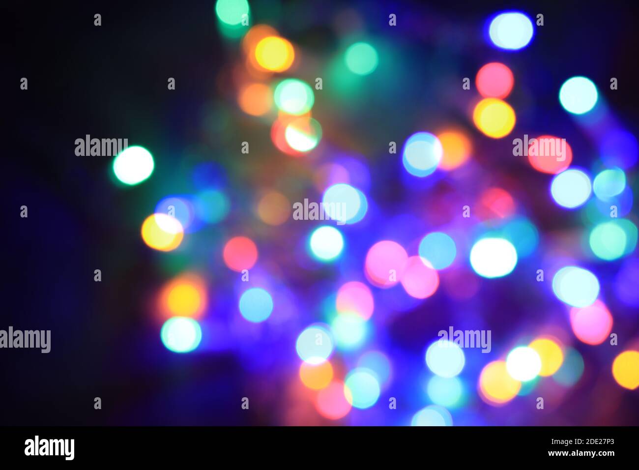 Lumière de Noël colorée floue sur fond noir Banque D'Images
