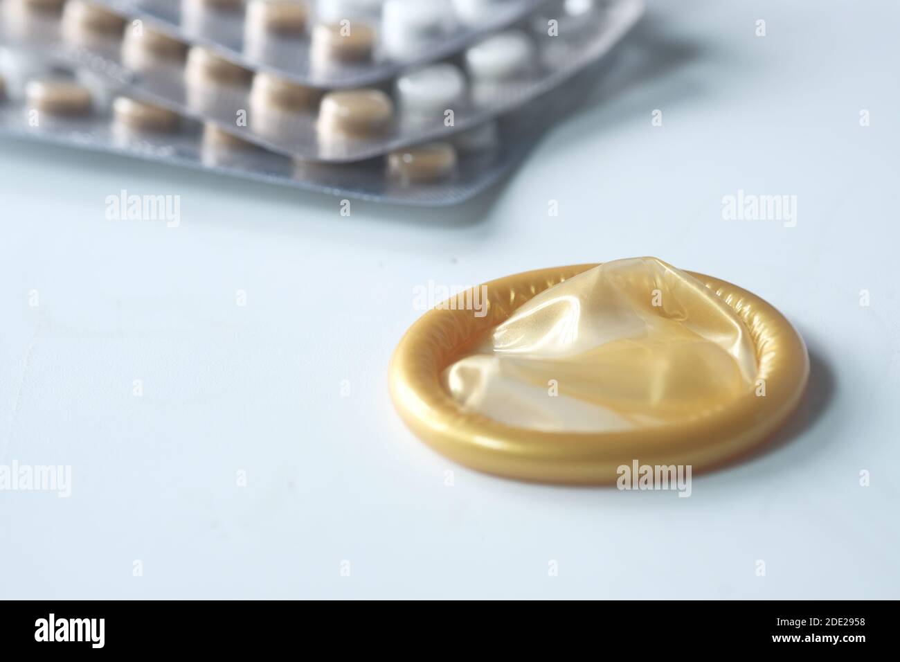 gros plan du préservatif et de la pilule contraceptive sur le blanc Banque D'Images