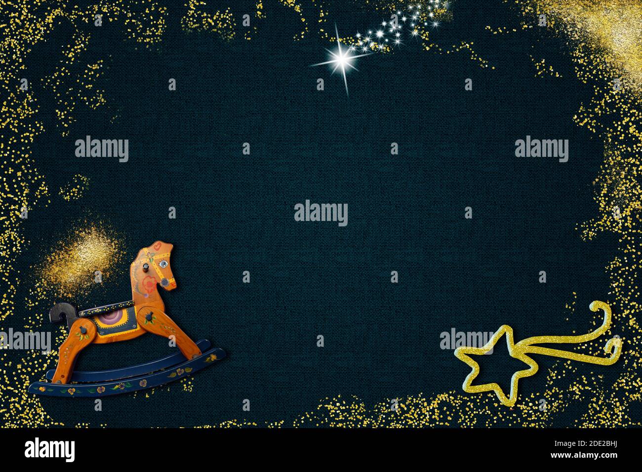 Arrière-plan de Noël pour les enfants. Cheval à bascule, étoile de Bethléem et paillettes dorées sur fond bleu foncé avec espace vide pour mettre des photos et du texte Banque D'Images