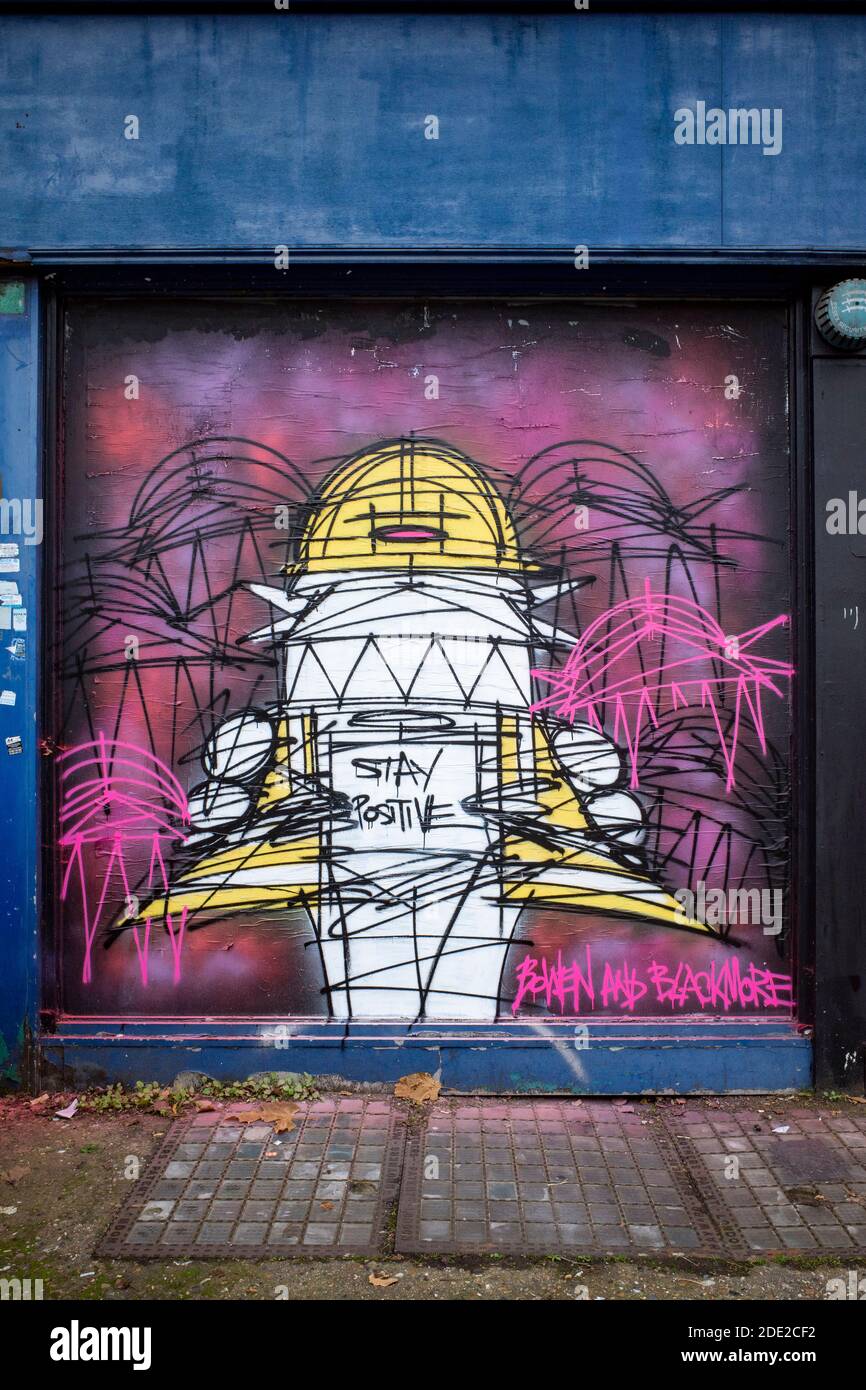 Restez positif graffiti par Nathan Bowen et Harry Blackmore sur un front de shopping avec volets sur Kentish Town Road dans le nord de Londres, un travail récent. Banque D'Images