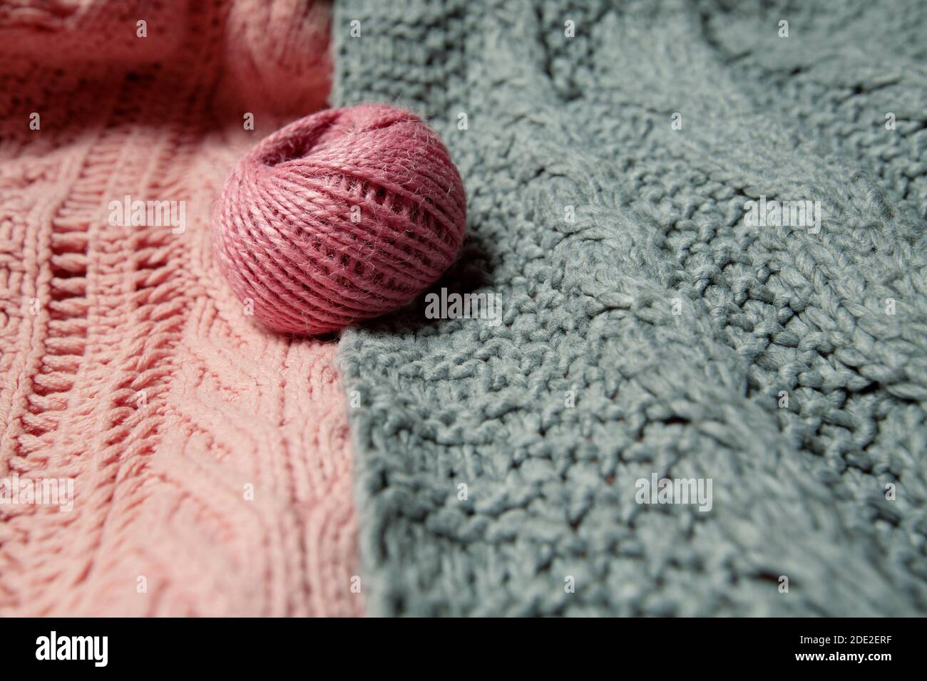 boule de laine rose sur pull gris et rose Banque D'Images