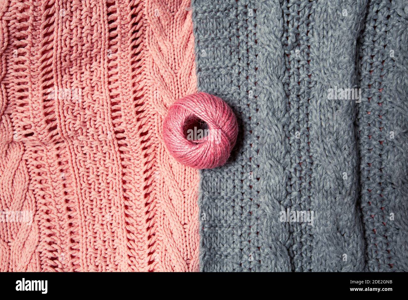 boule de laine rose sur pull gris et rose Banque D'Images