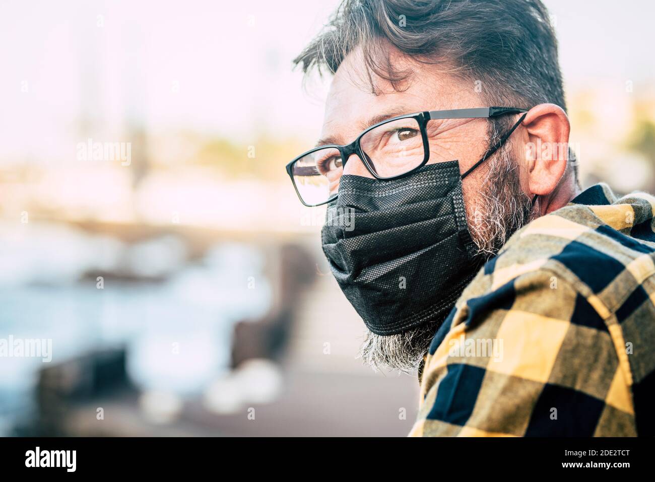 Gros plan portrait d'un beau homme avec un masque médical et des gloses pour protéger contre l'urgence pandémique covid-19 du coronavirus - personnes et mesures de sécurité Banque D'Images