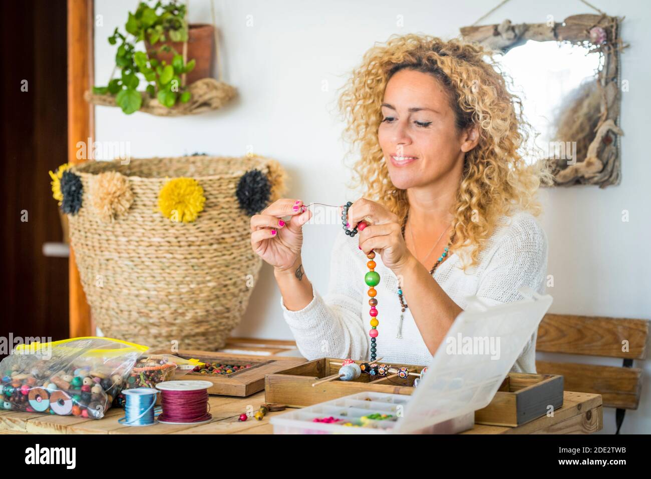 Femme joyeuse à la maison faisant des bracelets et colliers avec coloré perles - hobby art travail les gens le font soi-même concept - travail d'art pour les affaires en ligne Banque D'Images