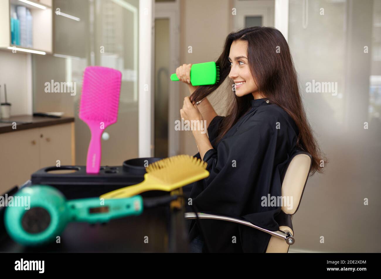 Une femme se fait coiffer dans un salon de coiffure Banque D'Images