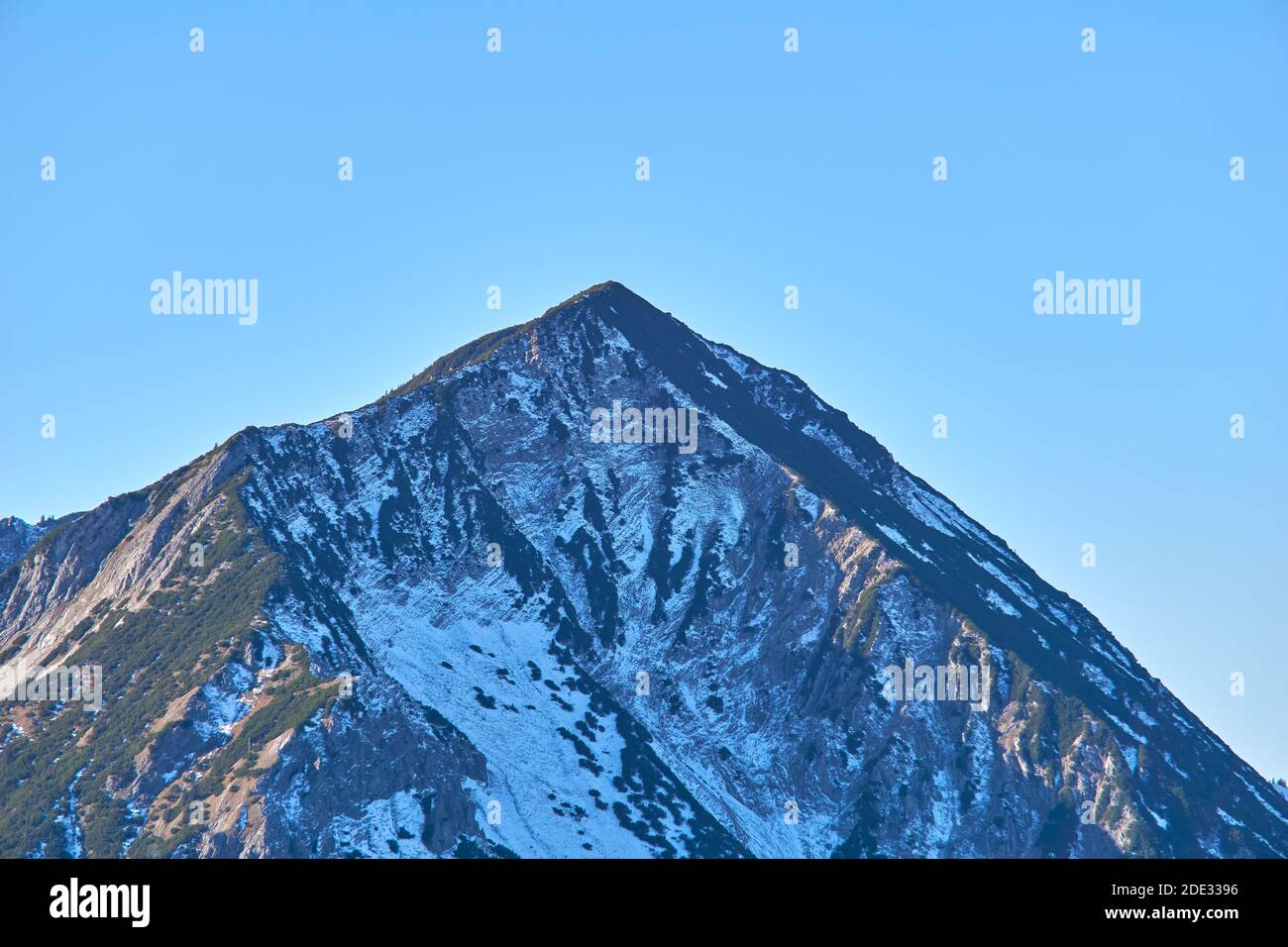 Montagne alpine solitaire en face du ciel bleu Banque D'Images