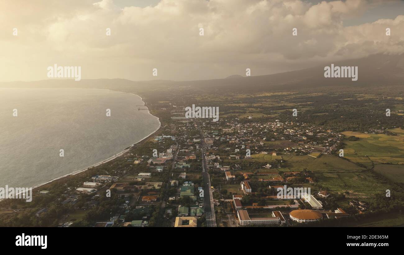 Paysage urbain au soleil aérien à la baie de l'océan. Rues urbaines avec maisons à la vallée verte. Paysage tropical de la nature au bord de la mer. Vacances d'été pittoresque à la journée ensoleillée avec la brume. Réflexion du soleil à la surface de l'eau Banque D'Images