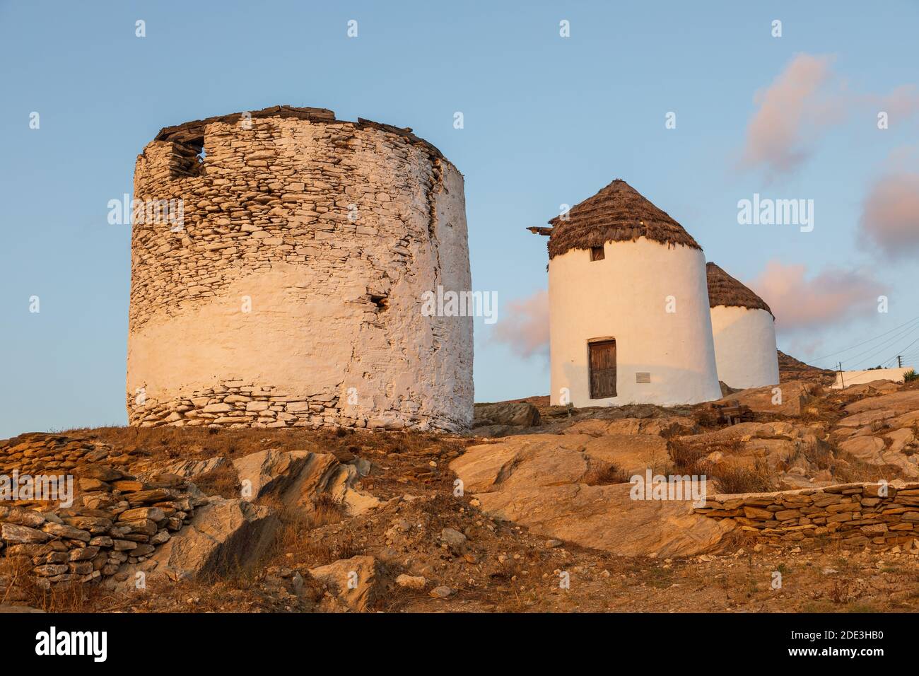 Moulins à vent traditionnels emblématiques sur la place principale de Chora. Coucher de soleil jaune. Colline avec petites chapelles en arrière-plan. Chora, île d'iOS, Grèce. Banque D'Images