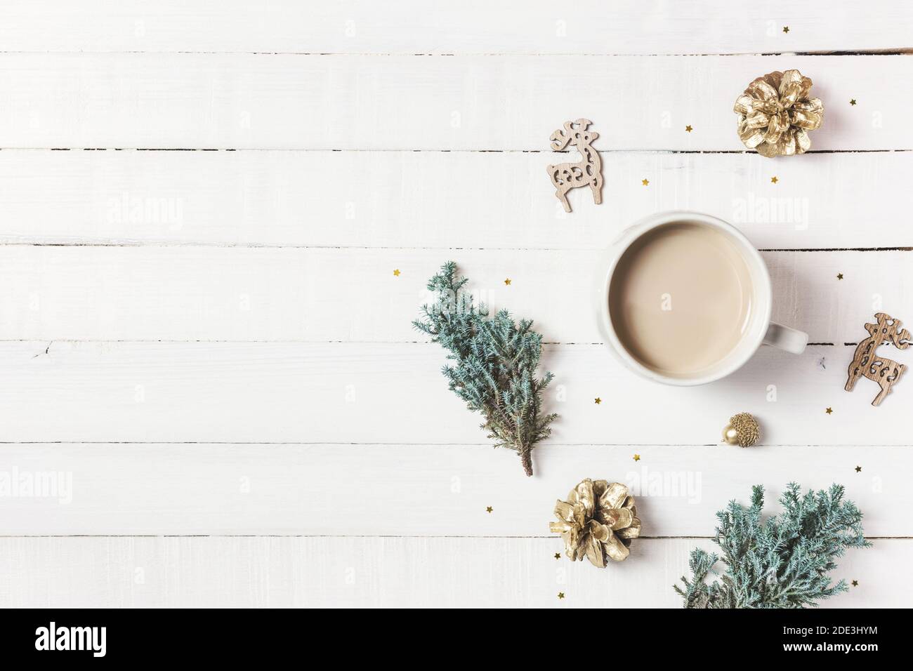 Composition de Noël. Tasse de café, arbre à feuilles persistantes et ornements sur fond de bois blanc. Hiver, concept de vacances. Plan d'affichage, vue de dessus, bac de copie Banque D'Images