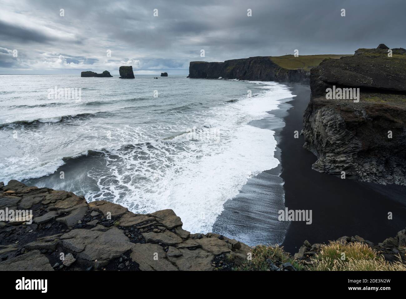 Vue panoramique sur la plage de Kirkjufjara et la péninsule de Dyrholaey, ciel nuageux, Islande du Sud Banque D'Images