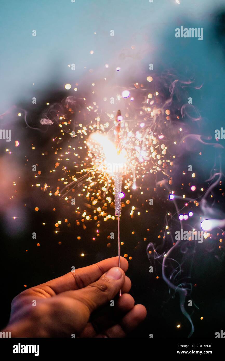Personne tenant un Sparkler éclairé pendant la nuit Banque D'Images