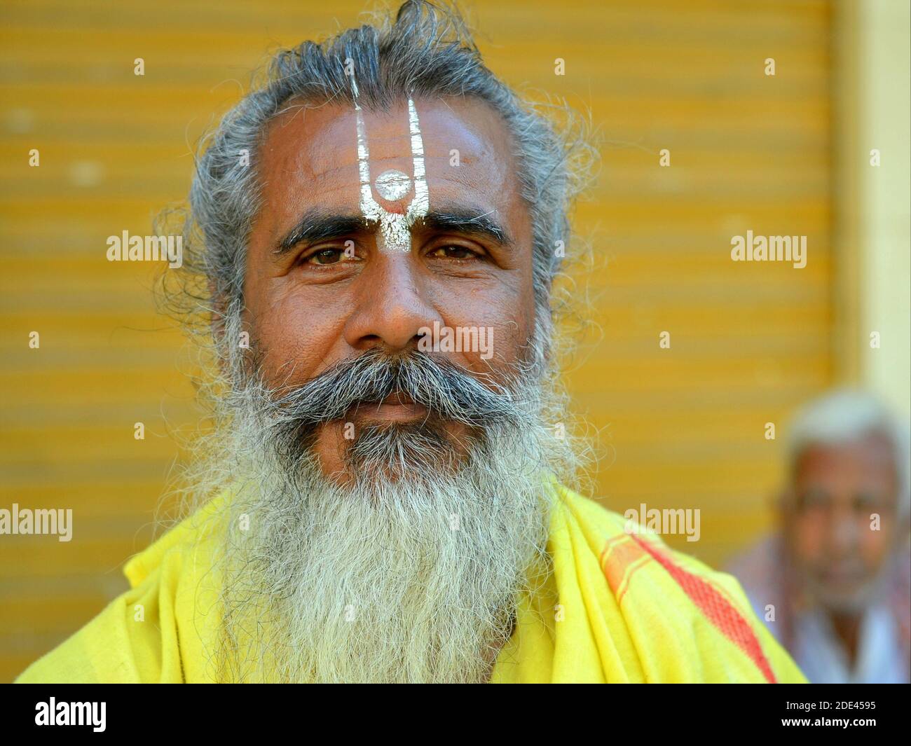 Sympathique positif Indien d'âge moyen Vaishnavite pèlerin hindou (vishnu sadhu) avec la peinture jaune urdhva pundra sur son front pose pour la caméra. Banque D'Images
