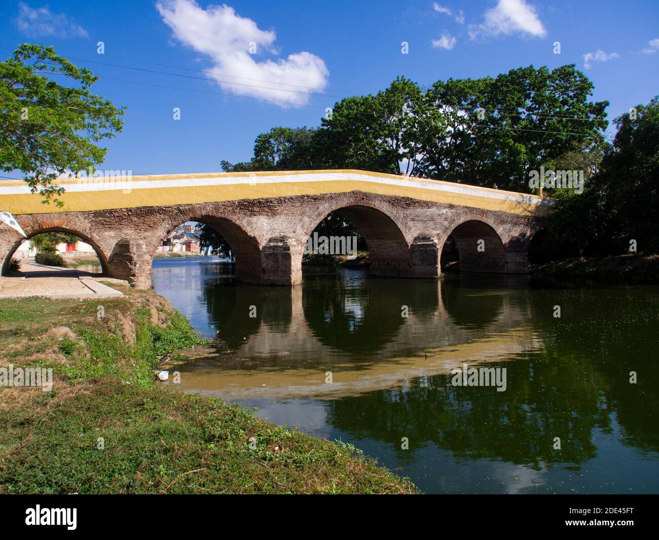 Ancien pont en pierre traversant une rivière, reflet du pont dans la rivière verte, cité rurale médiévale, jour ensoleillé Banque D'Images