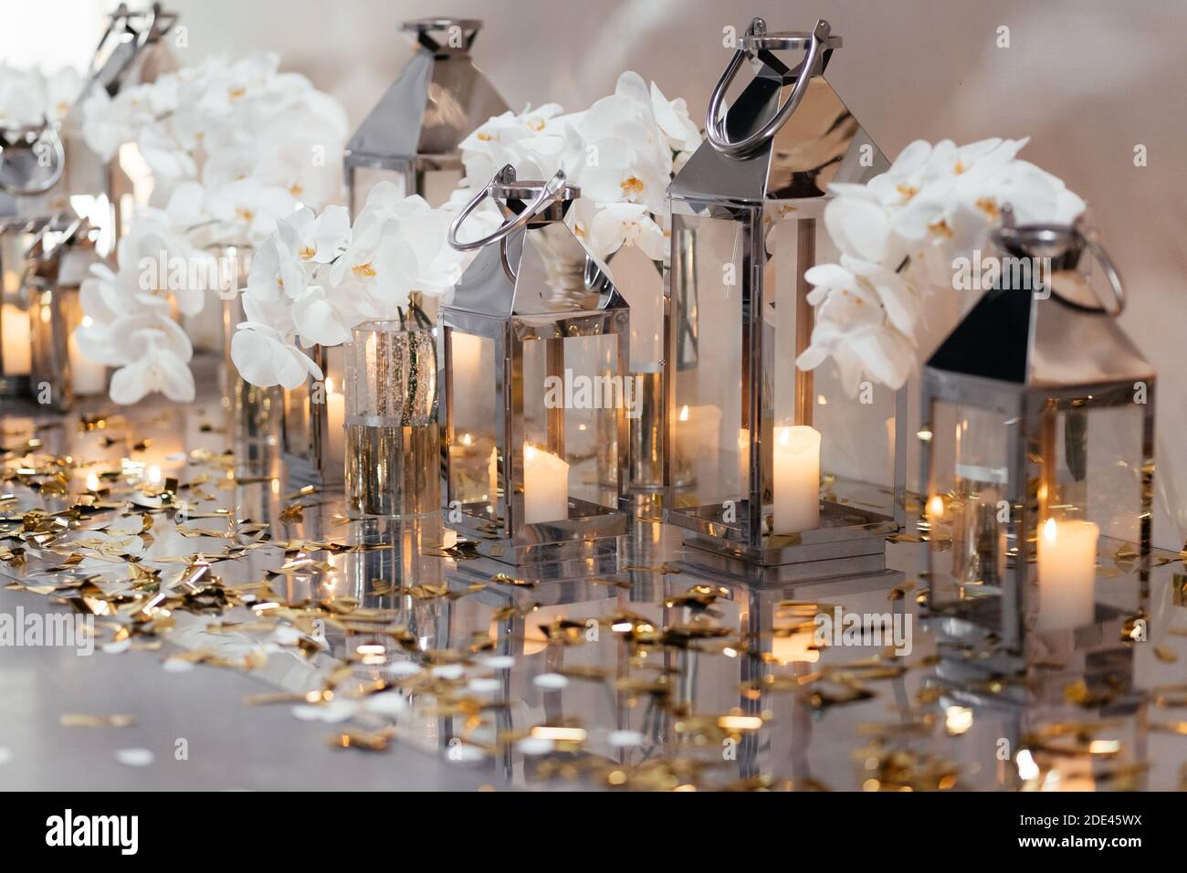 Petites bougies dans les chandeliers en verre décorés d'orchidées blanches. Décorations de restaurant de mariage. Banquet de mariage. Banque D'Images