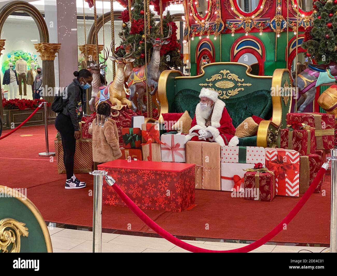 Philadelphie, Pennsylvanie, États-Unis. 28 novembre 2020. Une jeune fille maintient une distance sociale tout en visitant un Père Noël masqué au centre commercial King of Prussia Mall - visite avec le Père Noël pendant la COVID-19 - alors que le coronavirus se déforme aux États-Unis, les gens continuent à magasiner et à visiter le Père Noël dans un masque crédit: Don Mennig/Alay Live News Banque D'Images