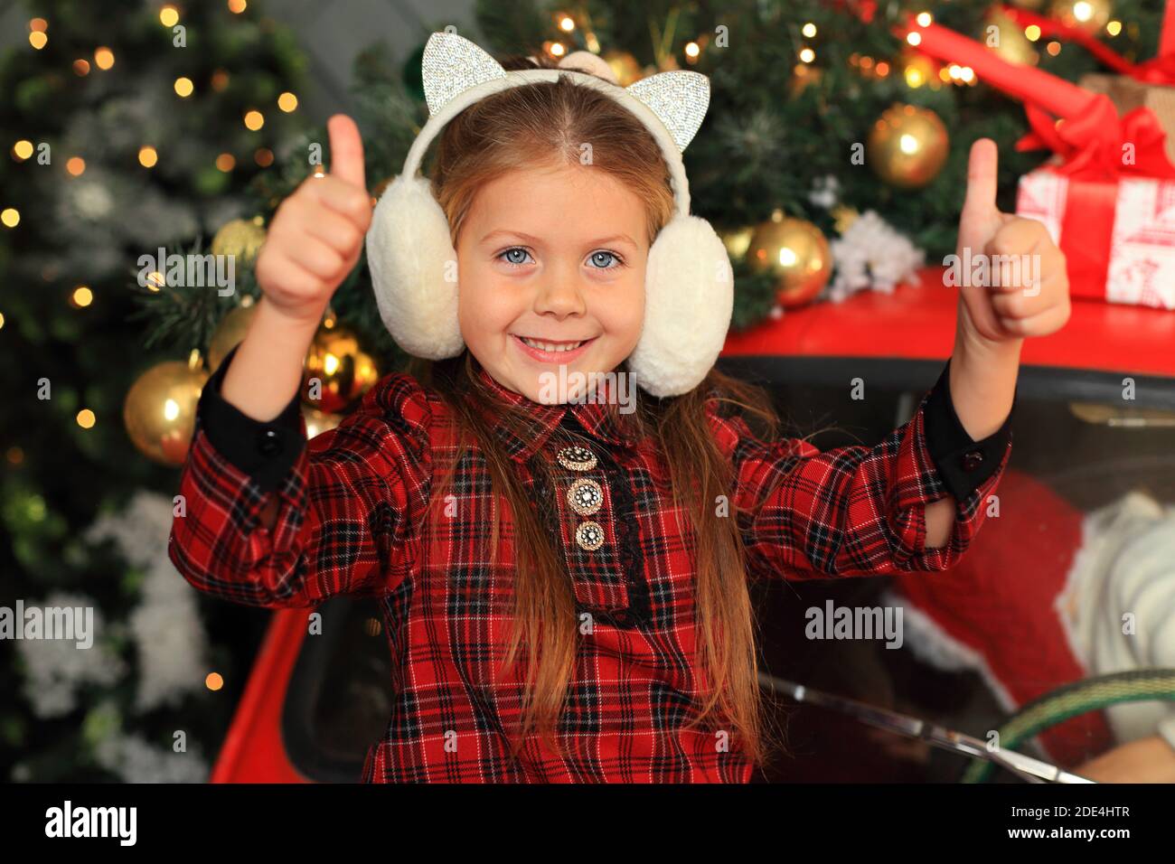 Bonne petite fille sur le fond de la décoration du nouvel an. L'enfant ressent des émotions Banque D'Images