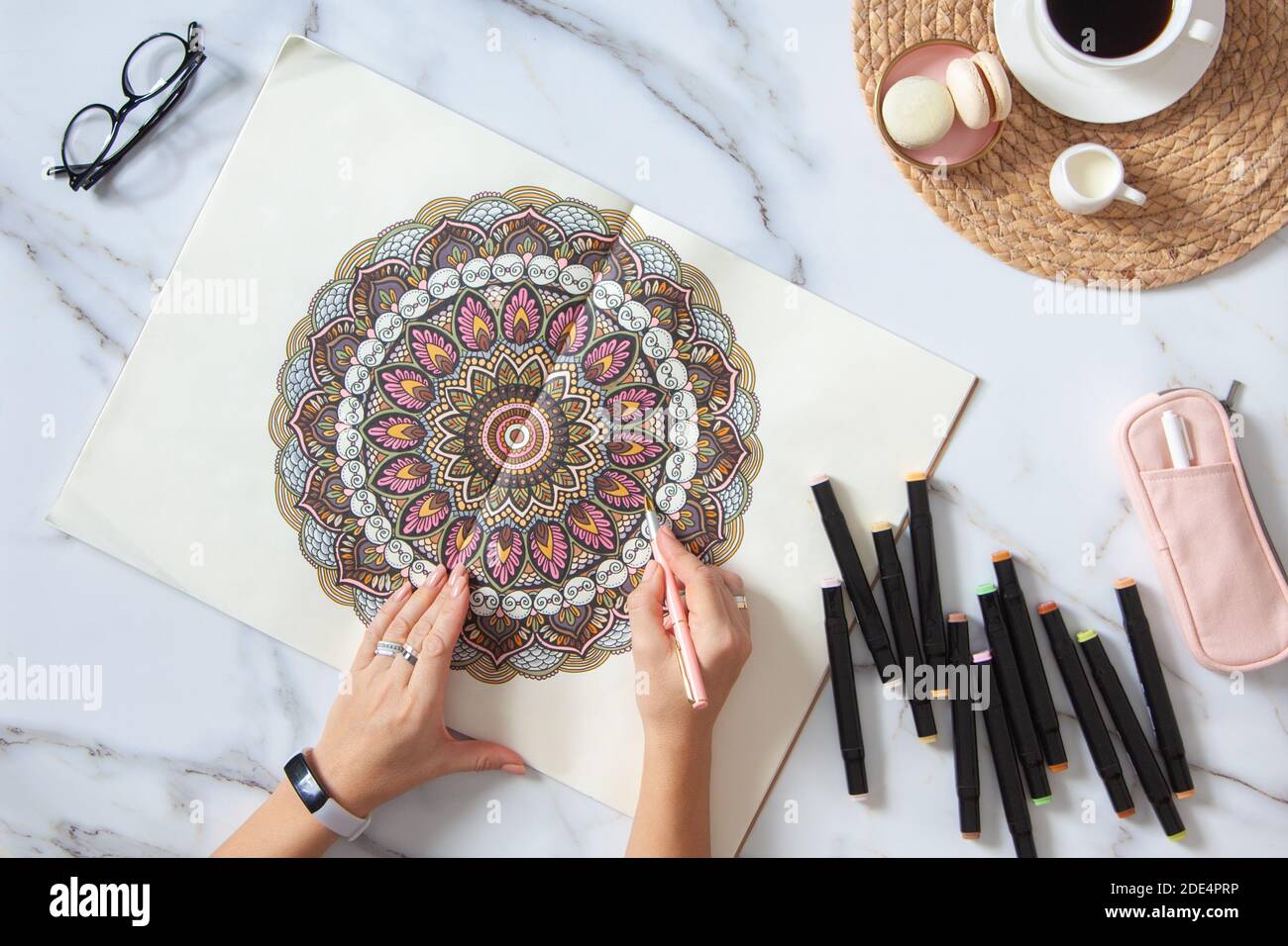 Femme dessin et coloriage de mandala dans des carnets de croquis avec des marqueurs colorés tout en prenant un petit déjeuner Banque D'Images