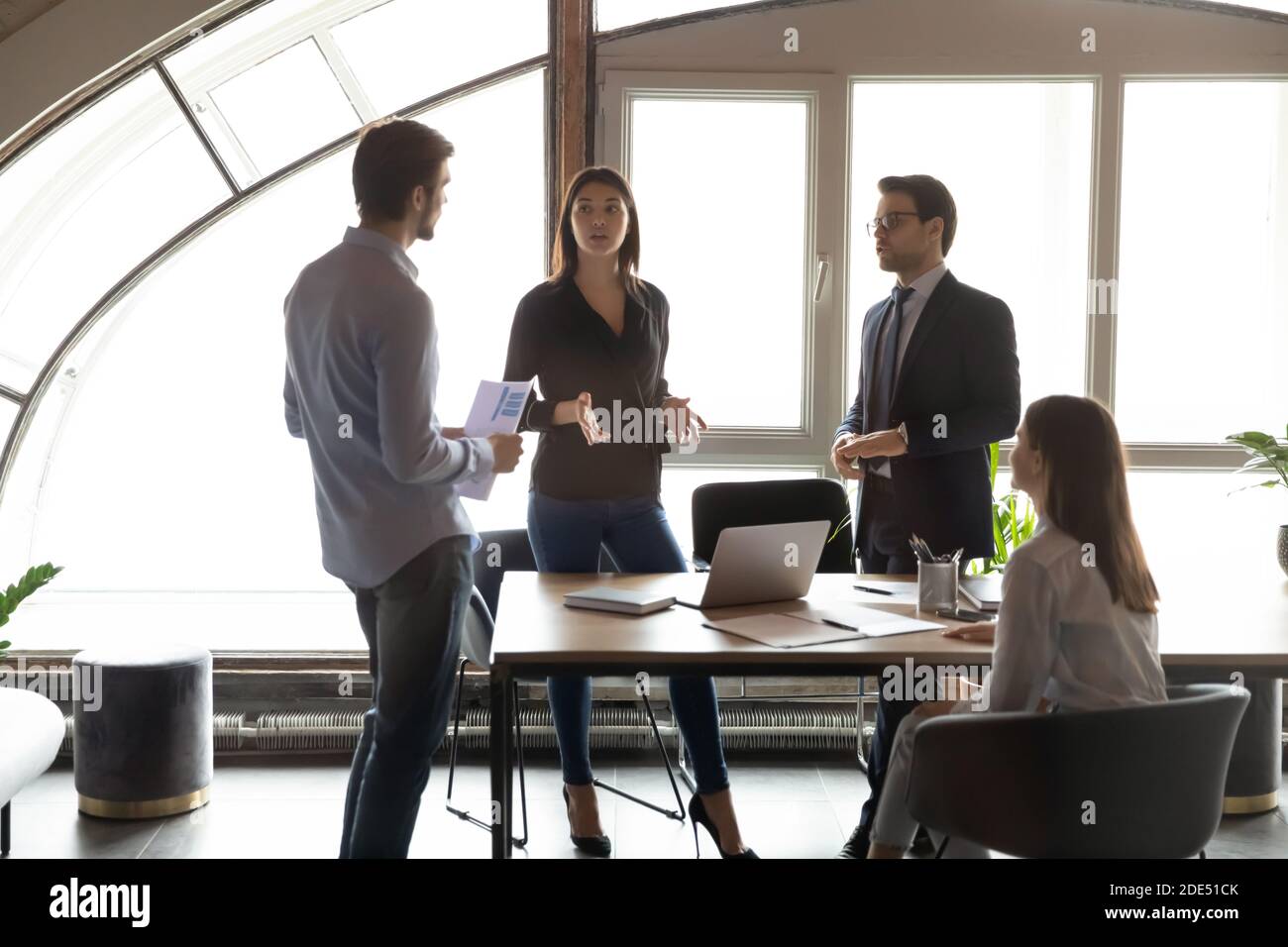 Coéquipiers multiethniques du millénaire concentrés partageant des idées de compétences lors d'un briefing Banque D'Images