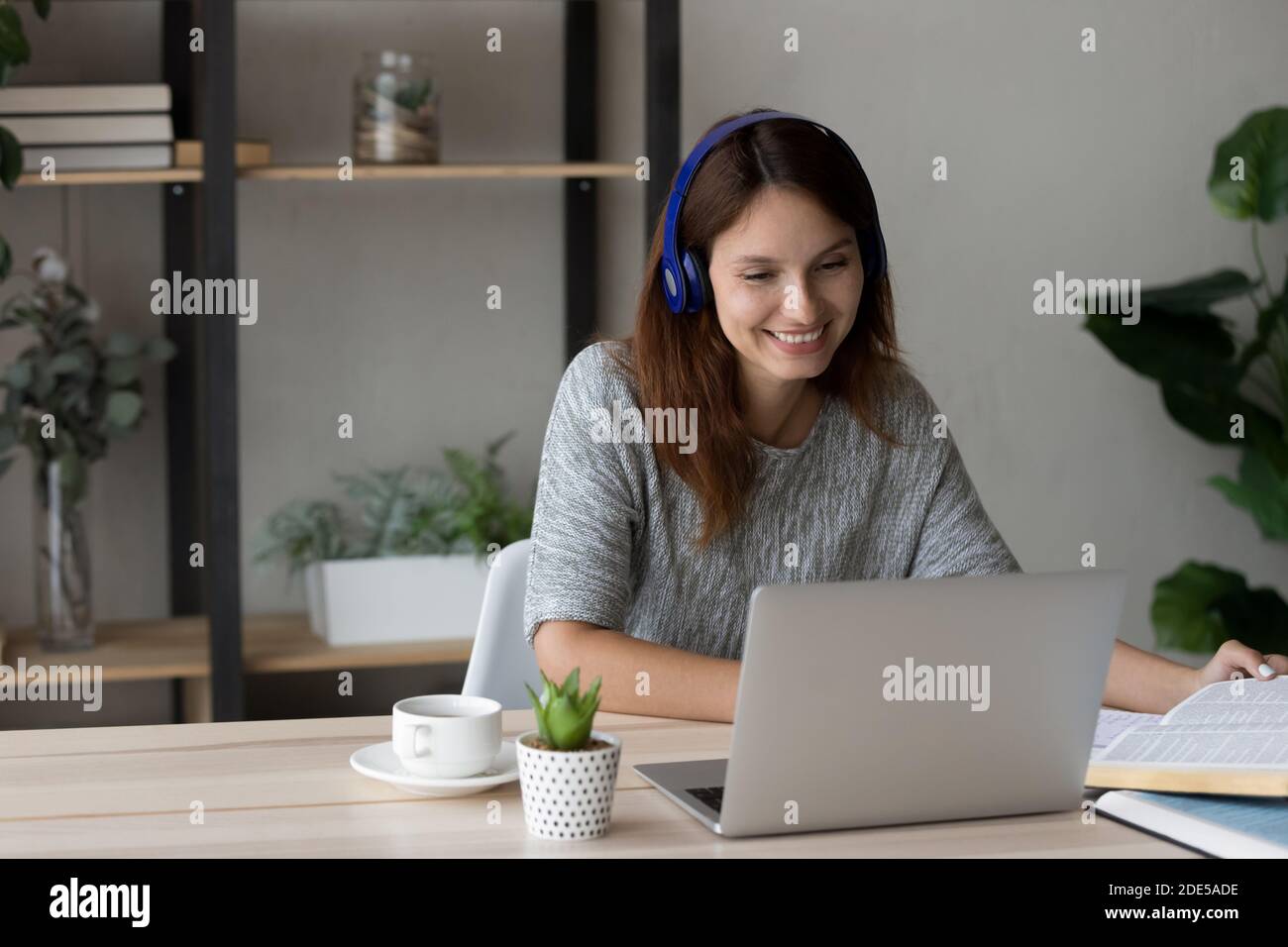 Femme millénaire souriante tenant une réunion par vidéoconférence sur ordinateur. Banque D'Images