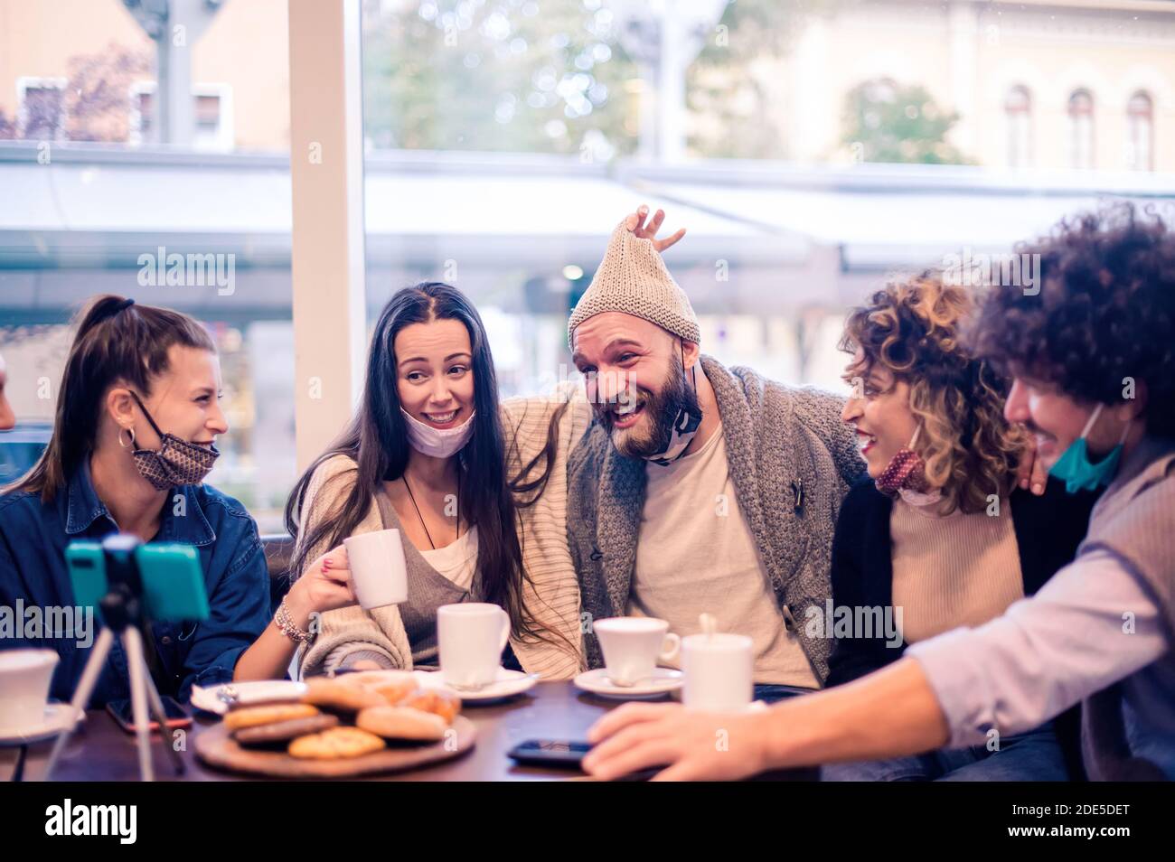 Les jeunes heureux partagent des moments avec leurs amis lors des appels vidéo Porter un masque ouvert - les influenceurs du millénaire ont du plaisir à se vlogging flux en direct à la charge Banque D'Images