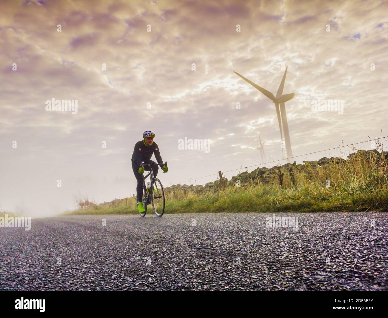 Parc éolien de Longpark Stow, frontières écossaises, Royaume-Uni. 29 novembre 2020. Météo, brume, matin frais. Des éoliennes apparaissent à partir de la brume basse au parc éolien de Longpark près de Stow, aux frontières écossaises, alors que le soleil du matin brûle la brume. Le cycliste Paul Richardson, photographié pour un petit matin frais, qui se déchaînait alors que la brume s'élève des champs. Crédit : phil wilkinson/Alay Live News Banque D'Images