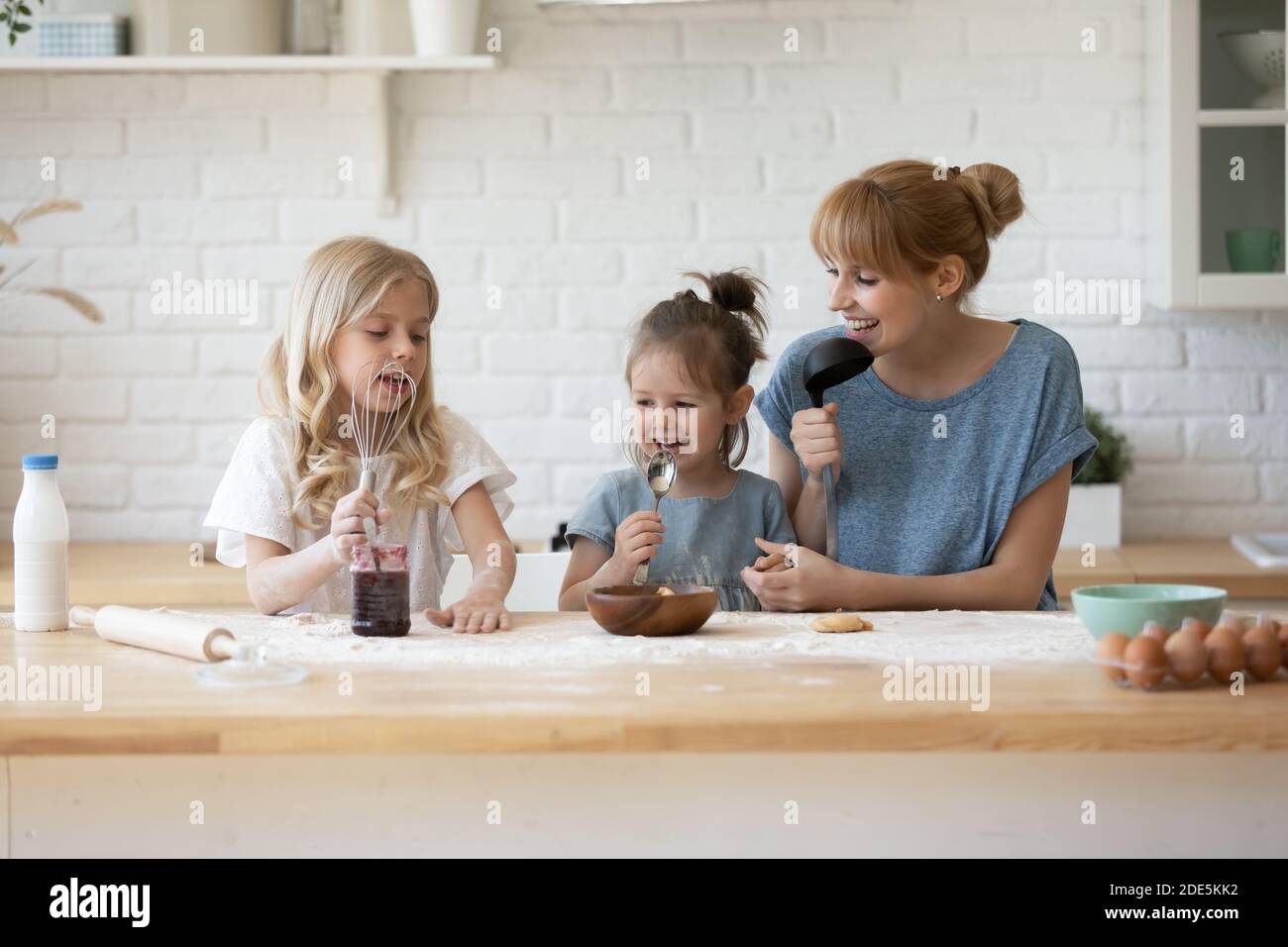 Bonne mère et deux adorables filles s'amusent dans la cuisine Banque D'Images