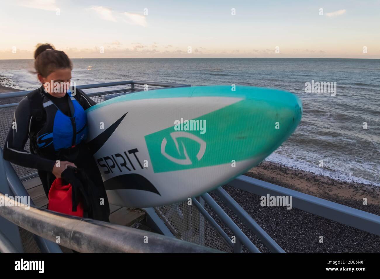 Angleterre, East Sussex, Eastbourne, Birling Gap, femelle Paddle Boarder se terminant à Beach Banque D'Images