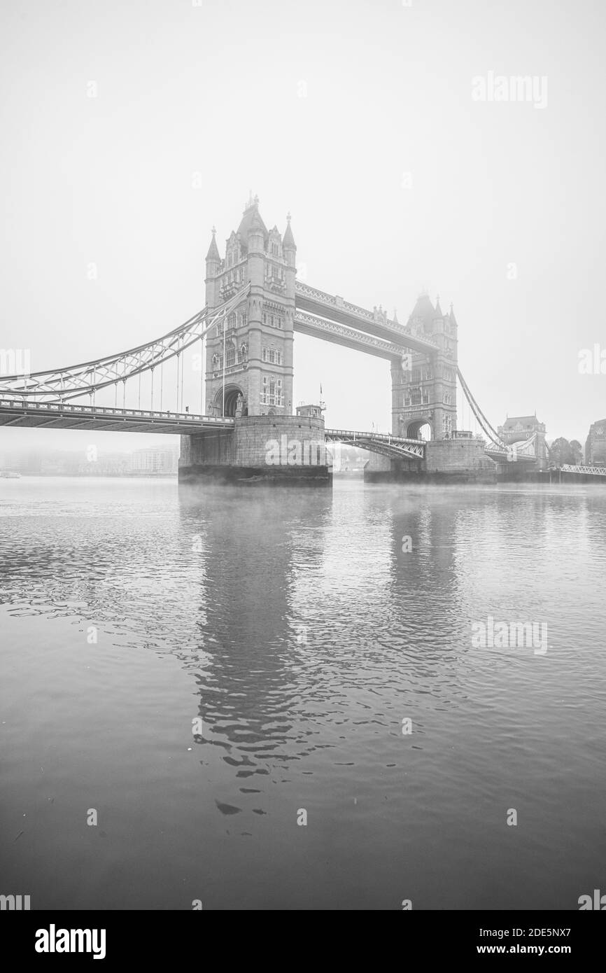 Tower Bridge noir et blanc et la Tamise dans une atmosphère brumeuse et brumeuse, au bord de l'eau dans des conditions météorologiques mauvaises à Londres City Centre sur le coronavirus Covid-19 LockDown Day One, Angleterre, Royaume-Uni Banque D'Images