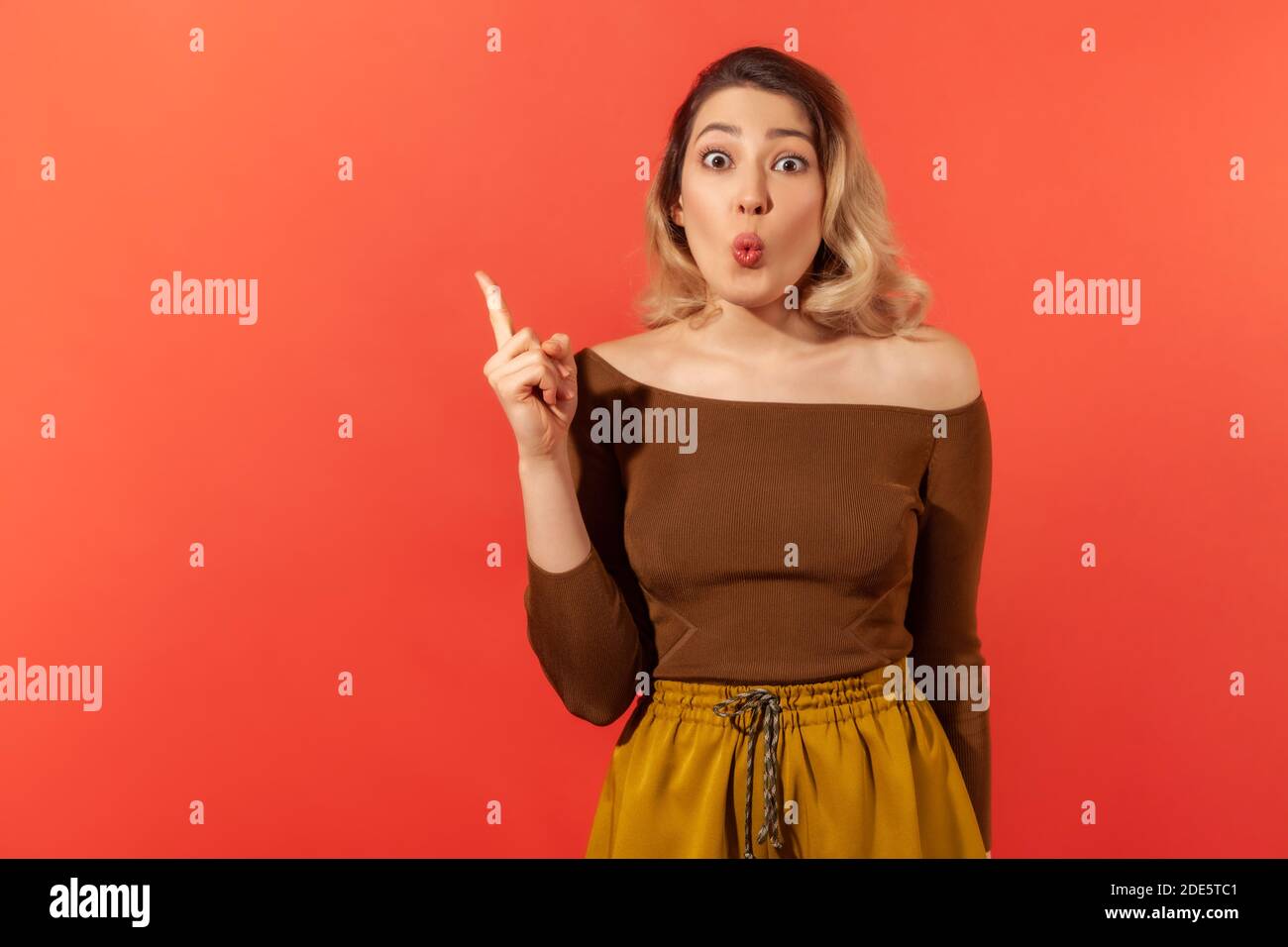 C'est une idée ! Portrait d'émerveillement jolie femme avec le visage surpris, a découvert quelque chose de nouveau ou d'obtenir la bonne réponse et lever son doigt vers le haut. Intelligent et Banque D'Images