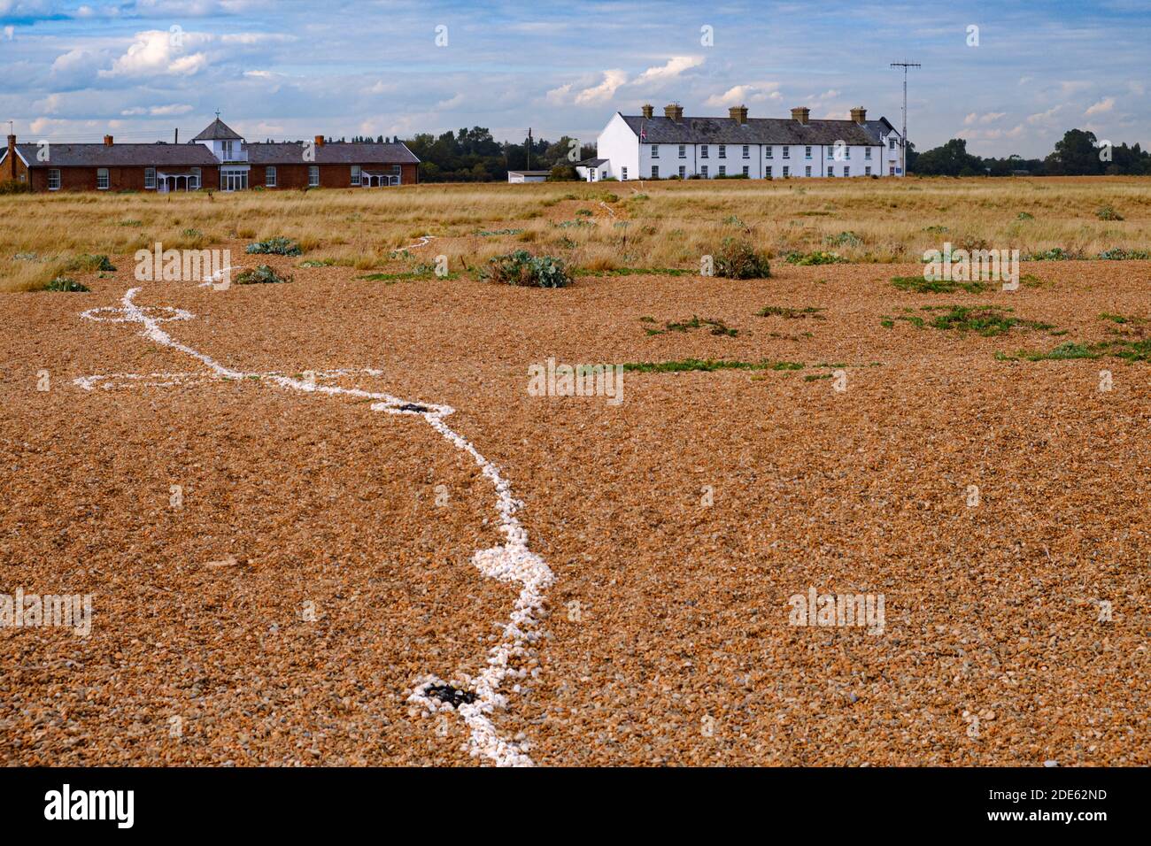Commencé comme un acte d'amitié il y a 13 ans, une ligne de coquillages serpente de la mer aux chalets de garde-côtes sur la plage de Shingle, Suffolk. Banque D'Images