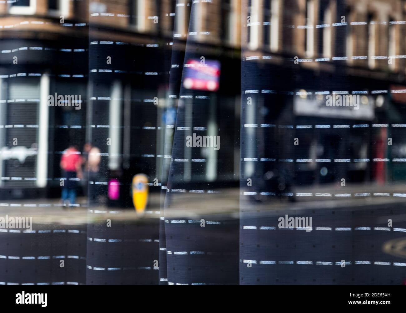 Réflexions à travers une vitrine de gens dans les rues, Glasgow Banque D'Images
