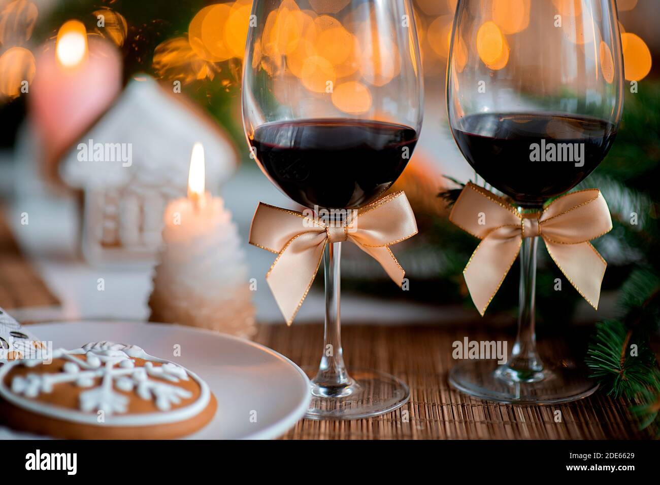 Ambiance de Noël festive avec deux verres de vin et une bougie sur la table de cuisine Banque D'Images