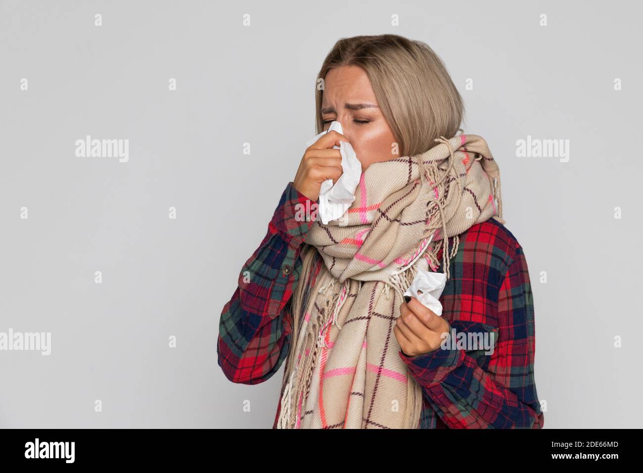 Contrarié malade femme éternuant ou utilisant la serviette pour essuyer le snot de son nez. La femme malade a la grippe. Rhinite, saison froide, maladie Banque D'Images