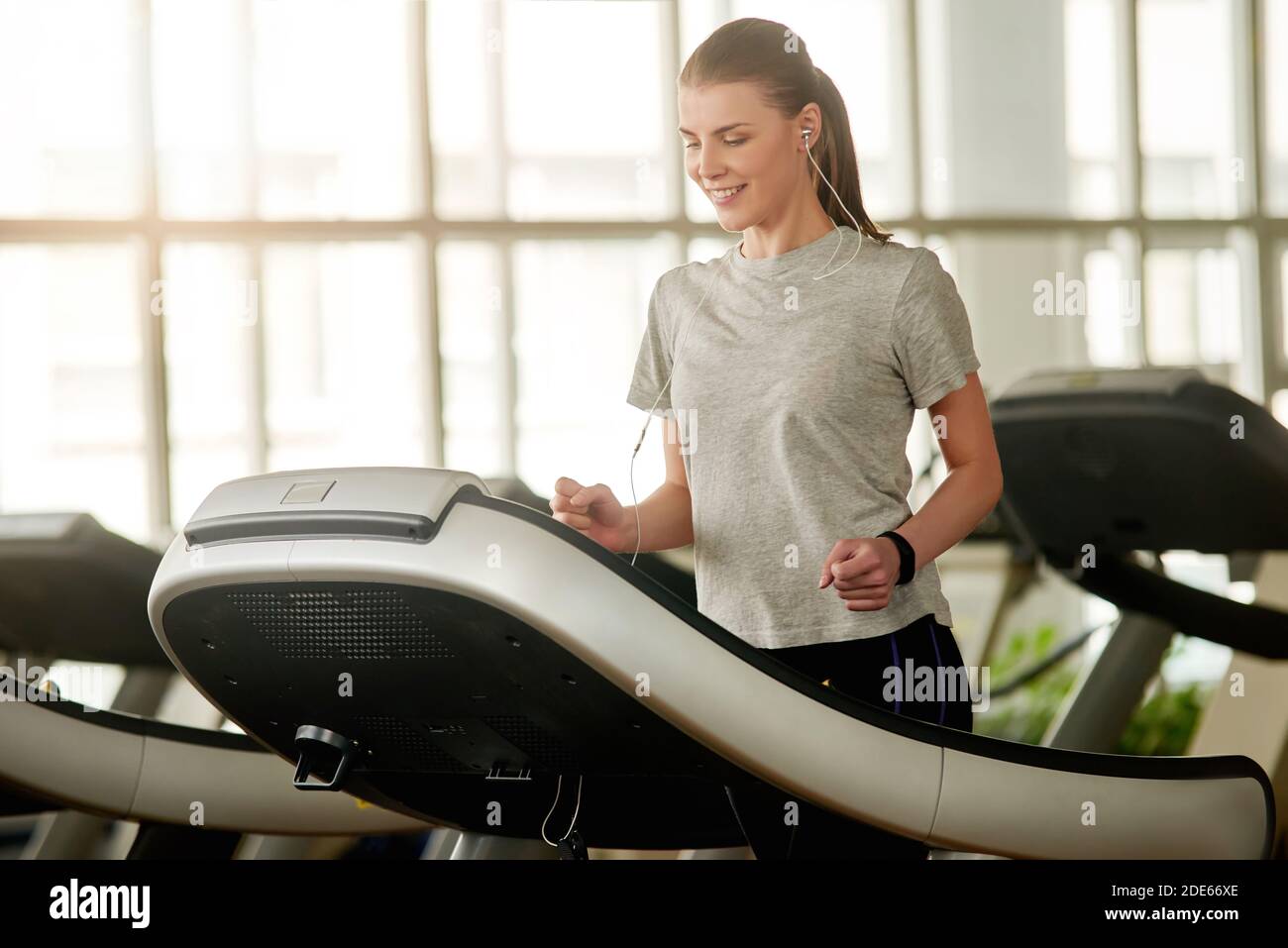 Jeune femme faisant de l'exercice cardio sur le tapis roulant dans la salle de gym. Banque D'Images